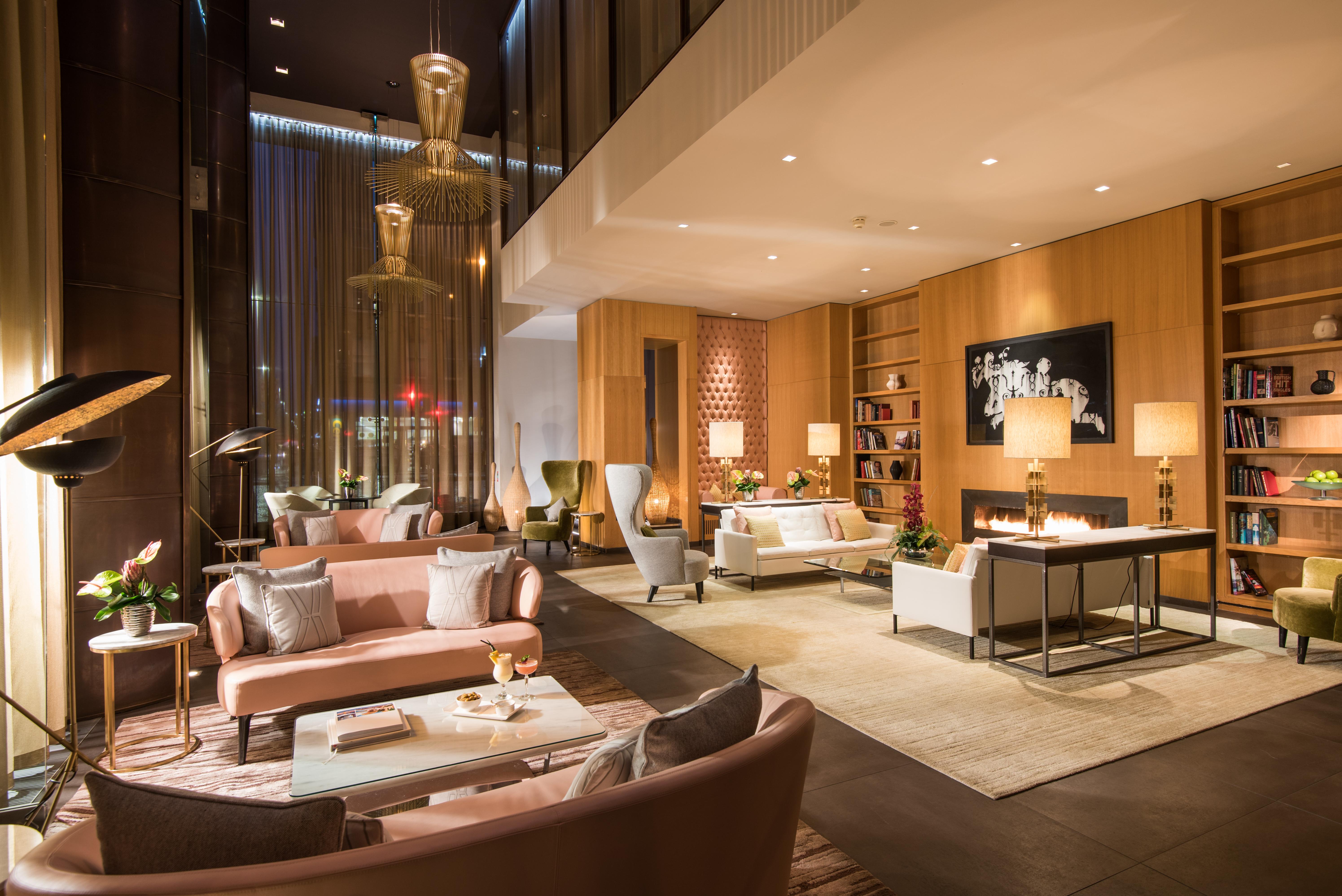 The Fitzwilliam Hotel Belfast Dış mekan fotoğraf The photo shows a modern and elegant lobby or lounge area. The space features a mix of contemporary and cozy furniture, including light-colored sofas and armchairs arranged around small tables. There are decorative elements like vases with flowers, a